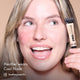 Heather smiling and holding HD PRO.Conceal Cool Nude beside her cheek.