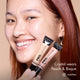 Crystal smiling and holding HD PRO.Conceal Peach and Bisque beside her cheek.