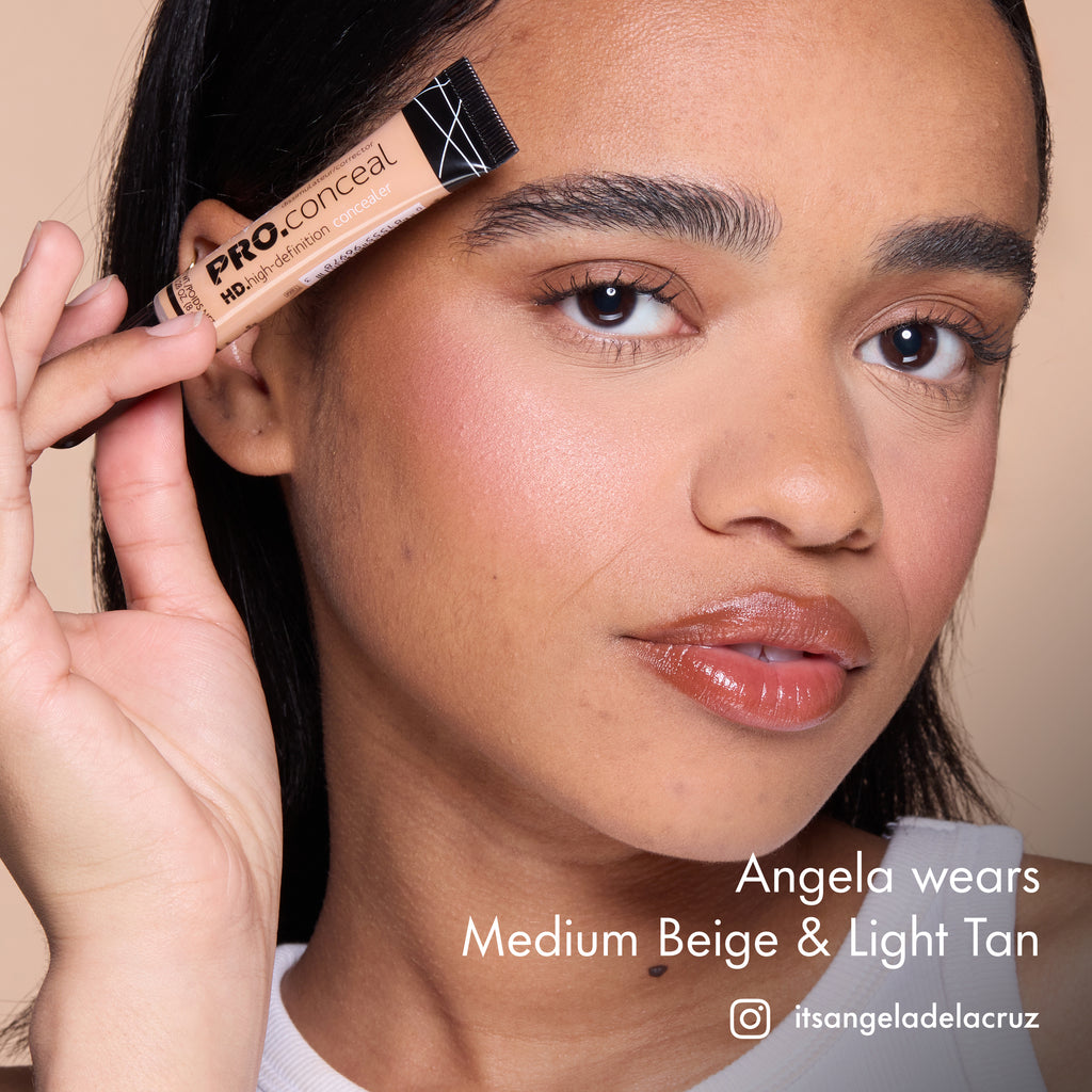 Angela wearing blended HD PRO.Conceal Medium Beige and Light Tan and holding a tube beside her forehead.