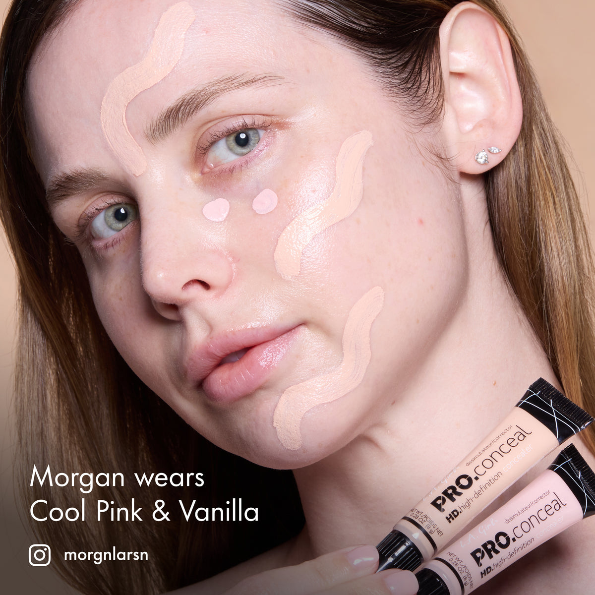 Morgan with HD PRO.Conceal Cool Pink and Vanilla dotted across her forehead, cheeks and chin, holding both tubes.