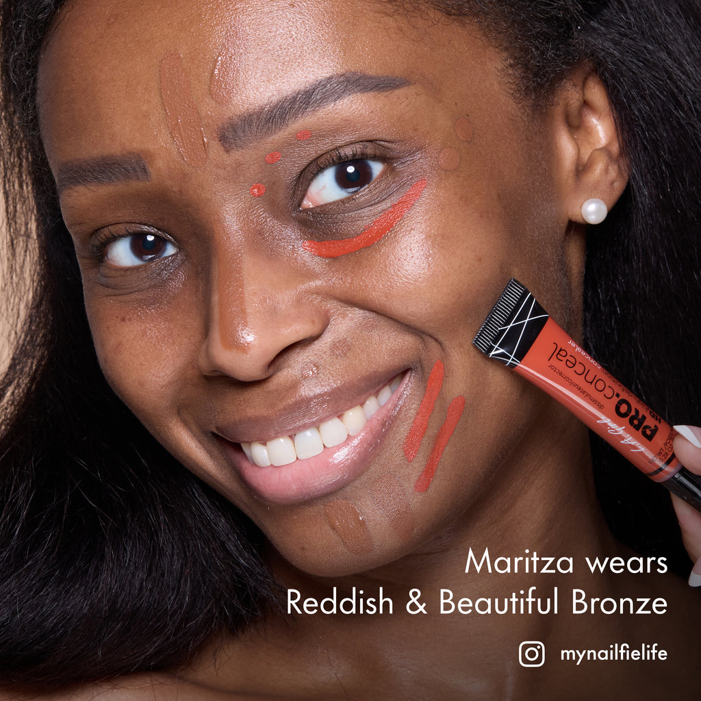 Maritza smiling with HD PRO.Conceal Reddish and Beautiful Bronze applied around her eyes and cheek, holding a tube.
