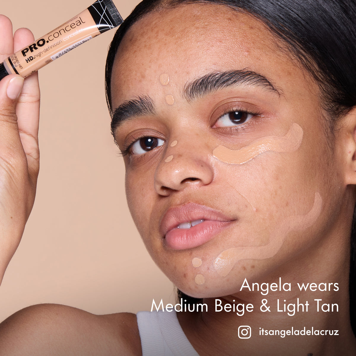 Angela with HD PRO.Conceal Medium Beige and Light Tan applied beneath her eyes and along her forehead and jaw, holding a tube.