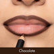 Close-up of a person applying chocolate-colored lipstick with a pencil.