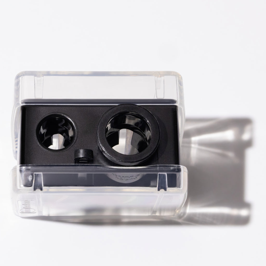 Double-sided pencil sharpener with clear plastic casing on a white background